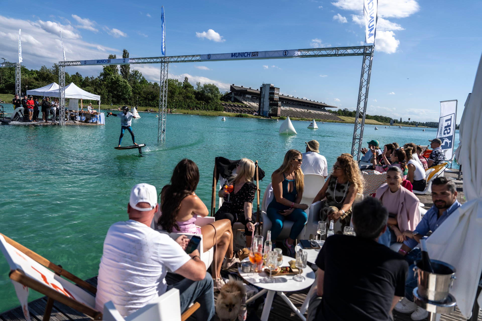 Besucher verfolgen ein Rennen entspannt von der Lounge direkt am Wasser