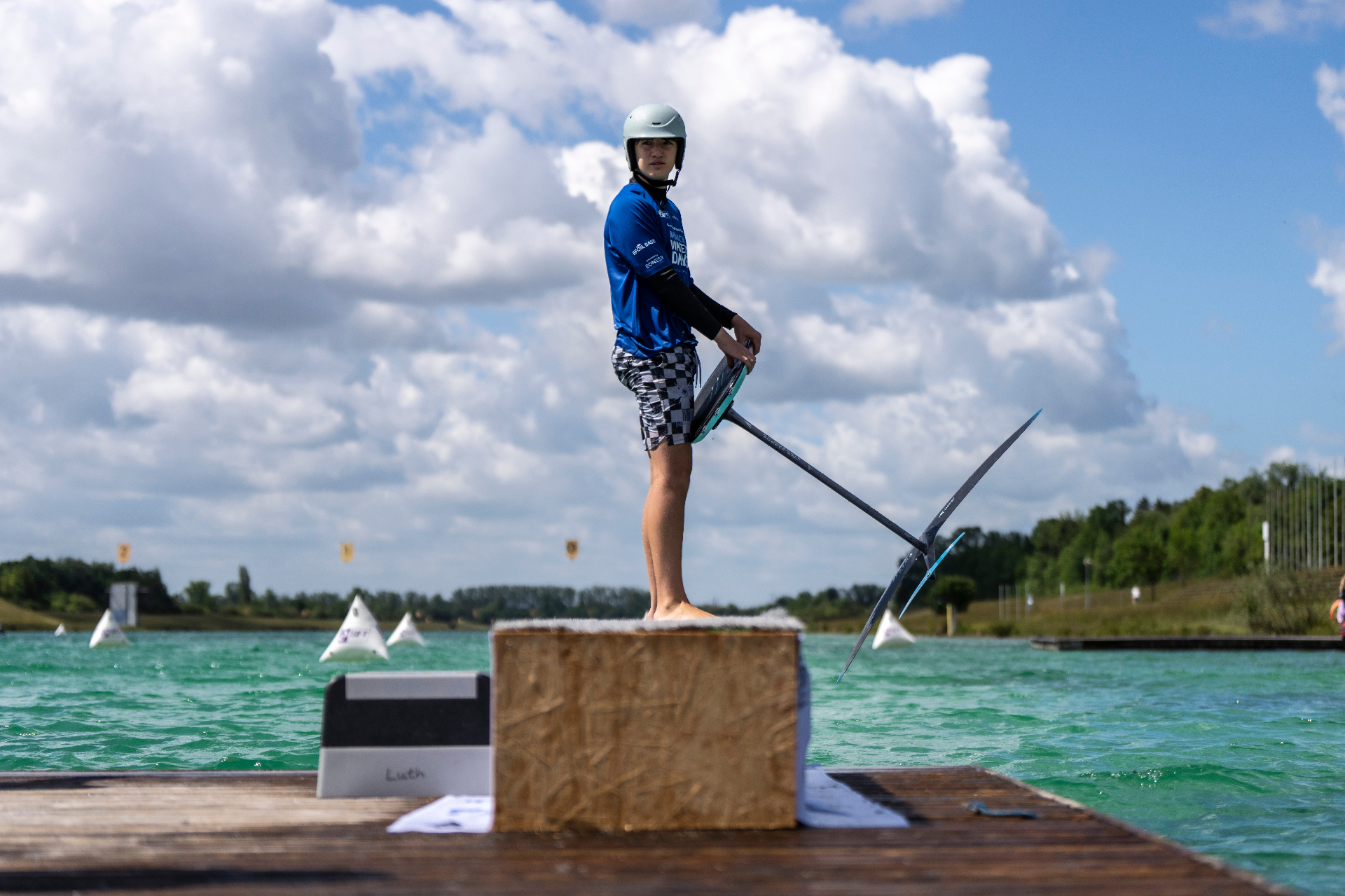 Junger Rider steht mit Foil-Board bereit für den Dockstart am Steg der Regattaanlage