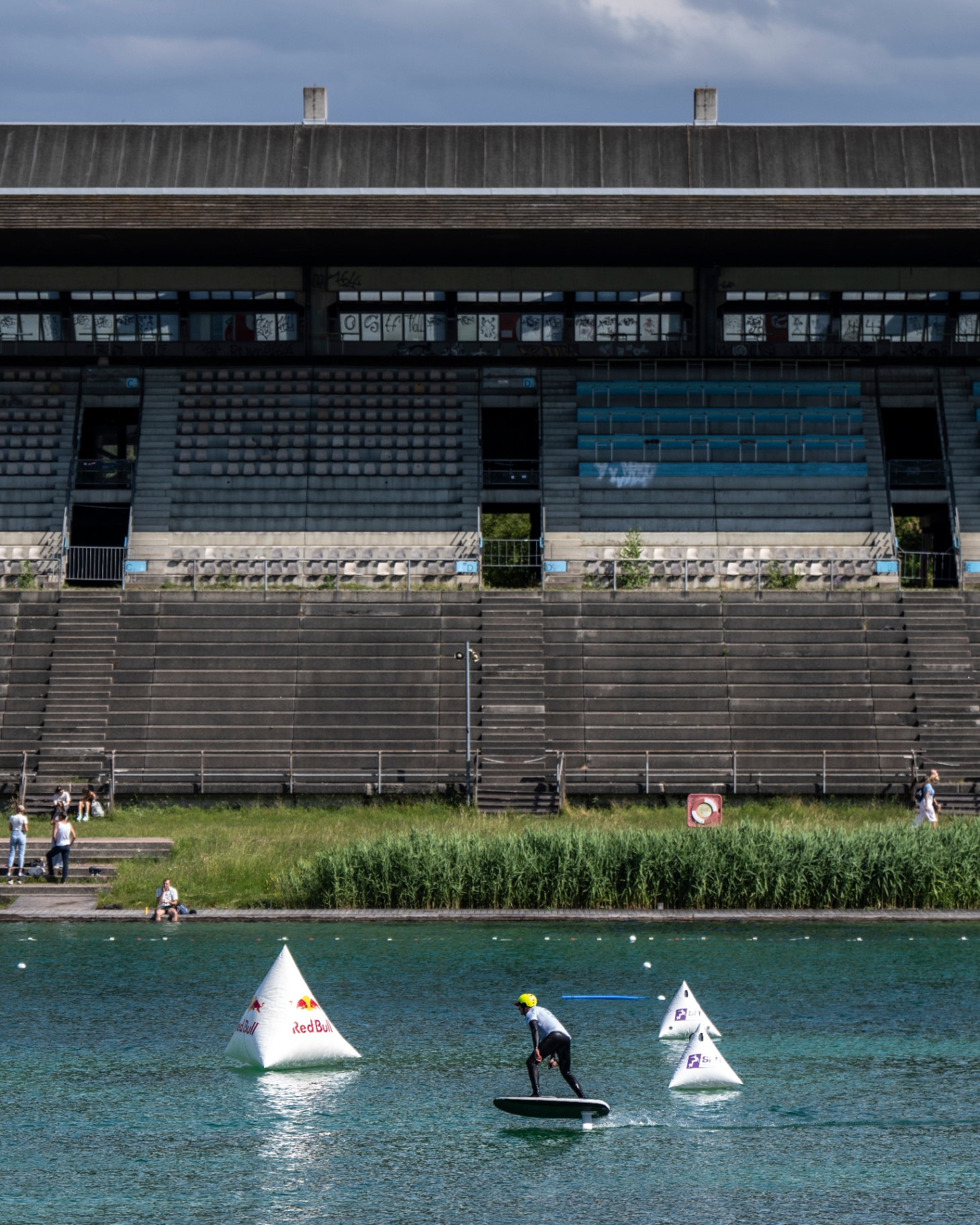 Foil-Rider auf dem Wasser vor der historischen Betontribüne der Regattaanlage