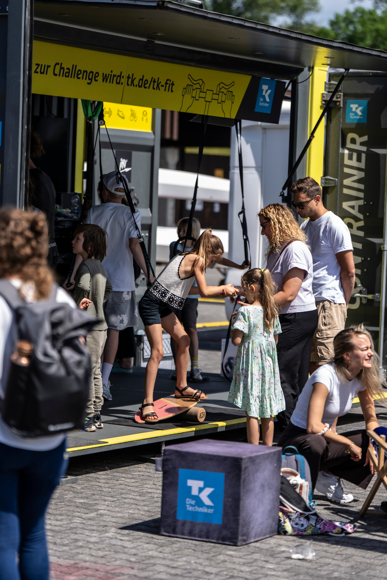 Familien am Techniker-Truck mit Balance-Board und Mitmach-Aktionen